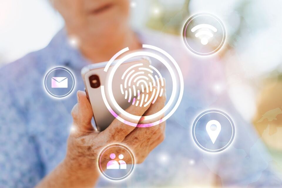 A traveller holding a phone, overlaid with a glowing fingerprint scan icon and other digital identity symbols.