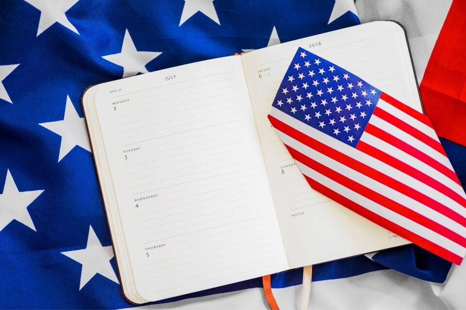 An open weekly diary and a small Stars and Stripes flag resting on a folded United States flag.